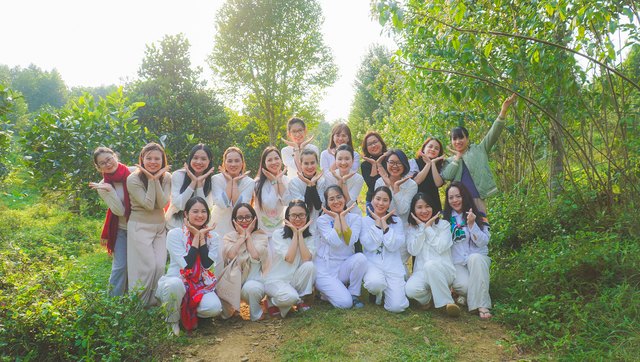 Học viên Level 2 mặc đồ trắng chụp ảnh chung trong vườn cây buổi sớm