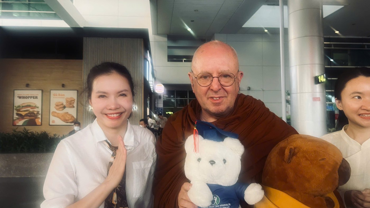 Moon Nguyễn chắp tay đứng cạnh thiền sư Ajahn Brahm